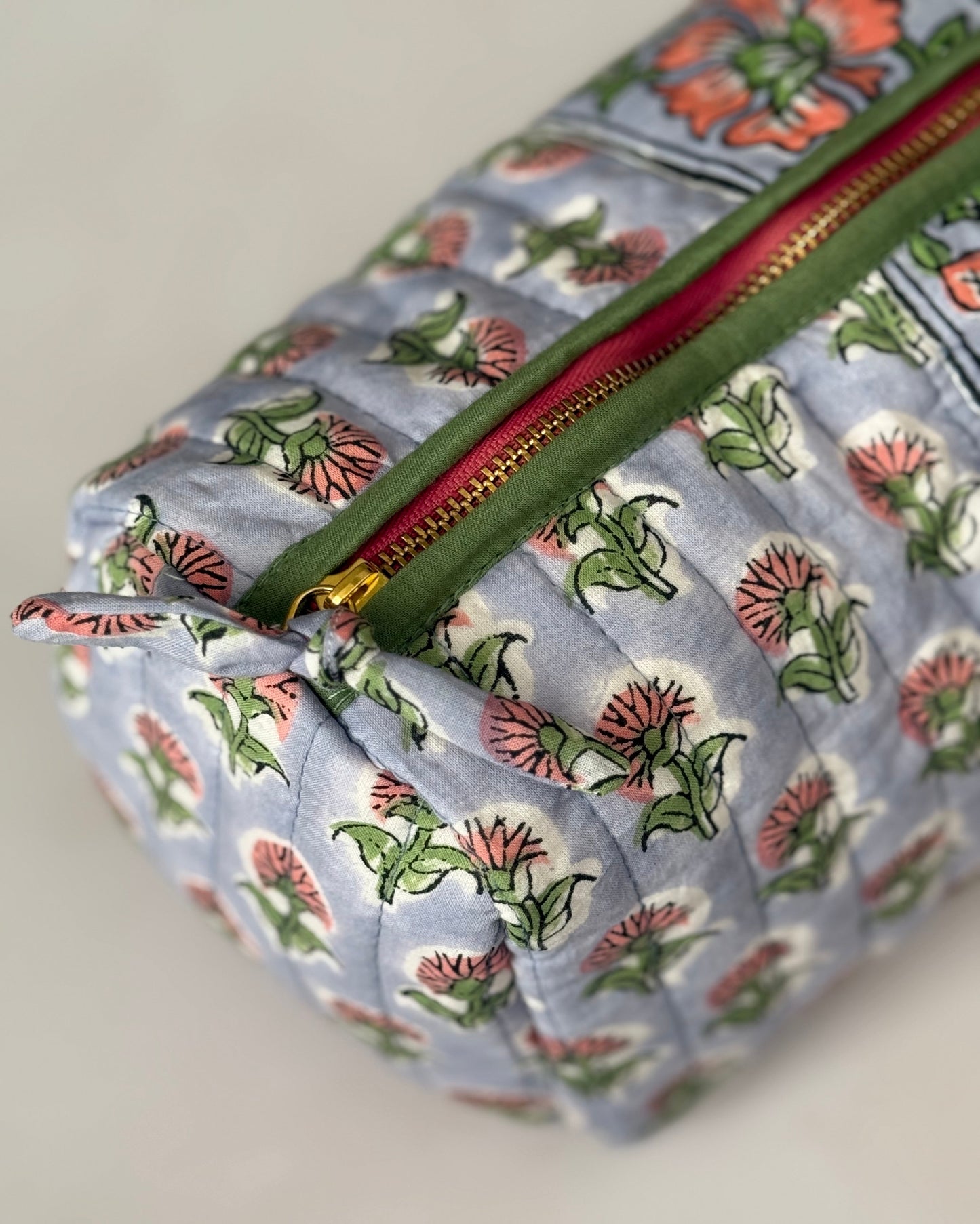 Detail view of gold zip with green piping a