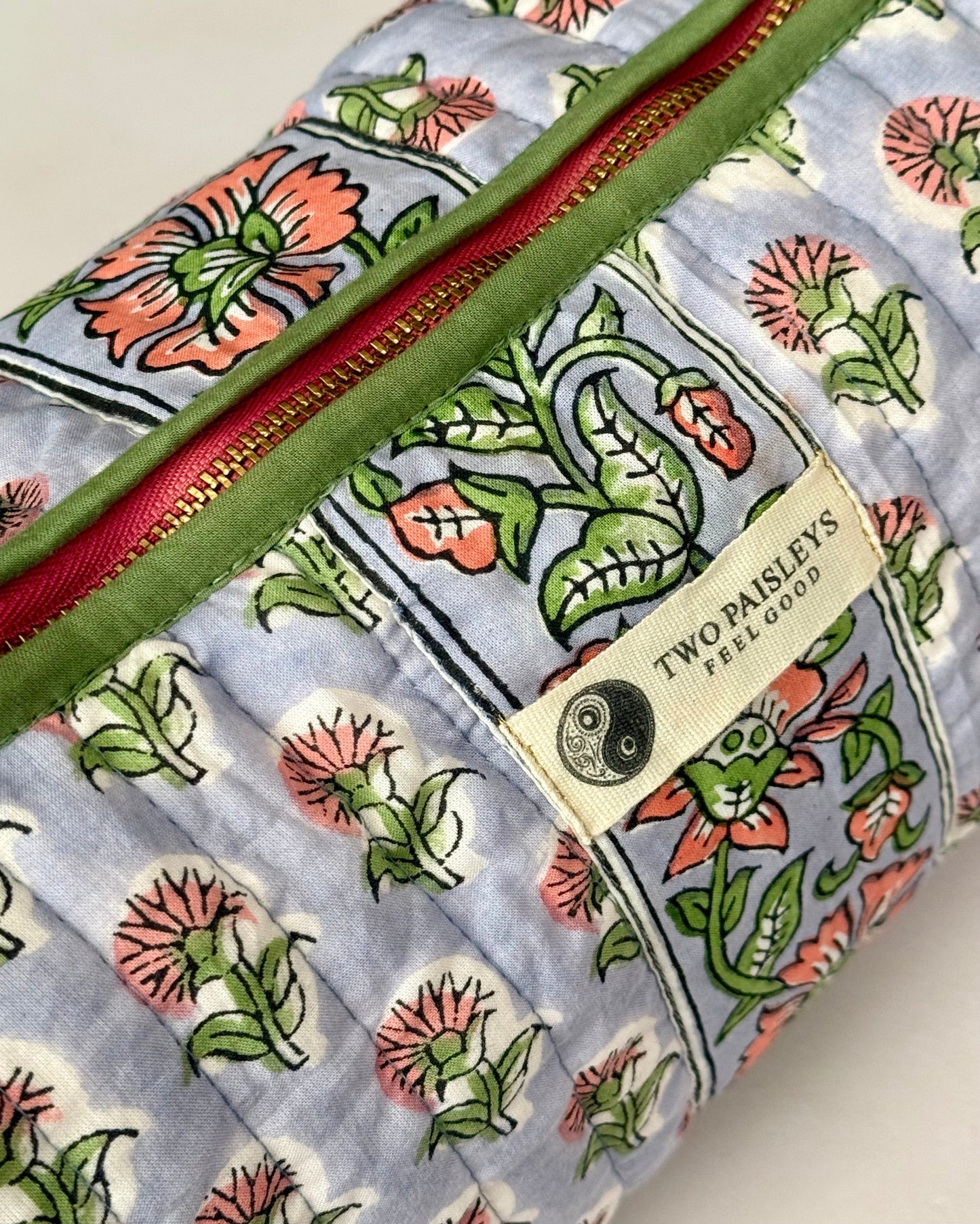 Side profile of the structured cotton wash bag showing floral pattern.
