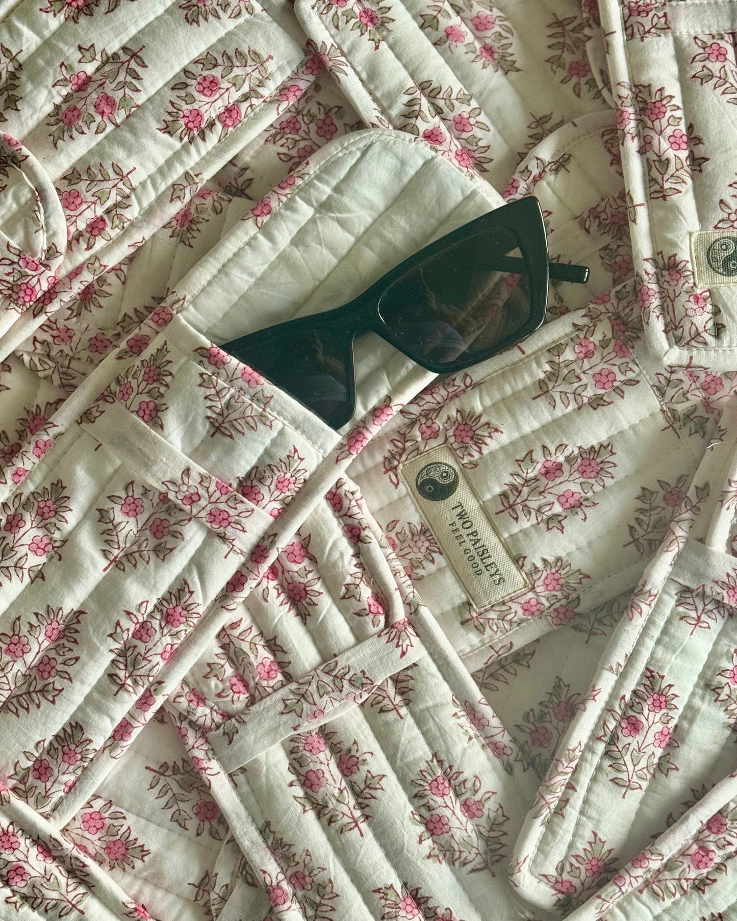 Sunglasses on vintage floral quilted glasses case with Two Paisleys logo