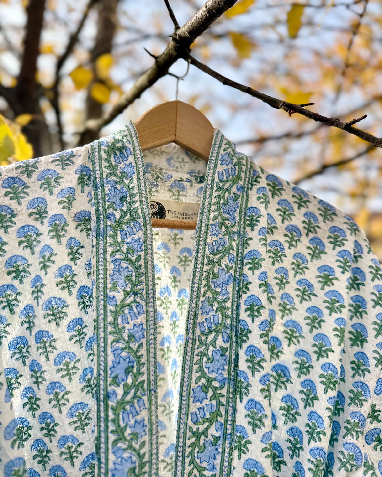Close-up detail of the 'Blue Blossom' waffle robe collar, showing the 'Two Paisleys' brand label.