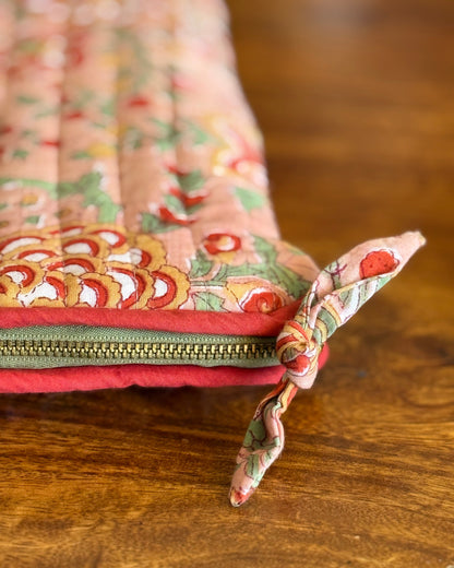 Close-up of quilted laptop sleeve zip with fabric knot pull, artisan handmade detail