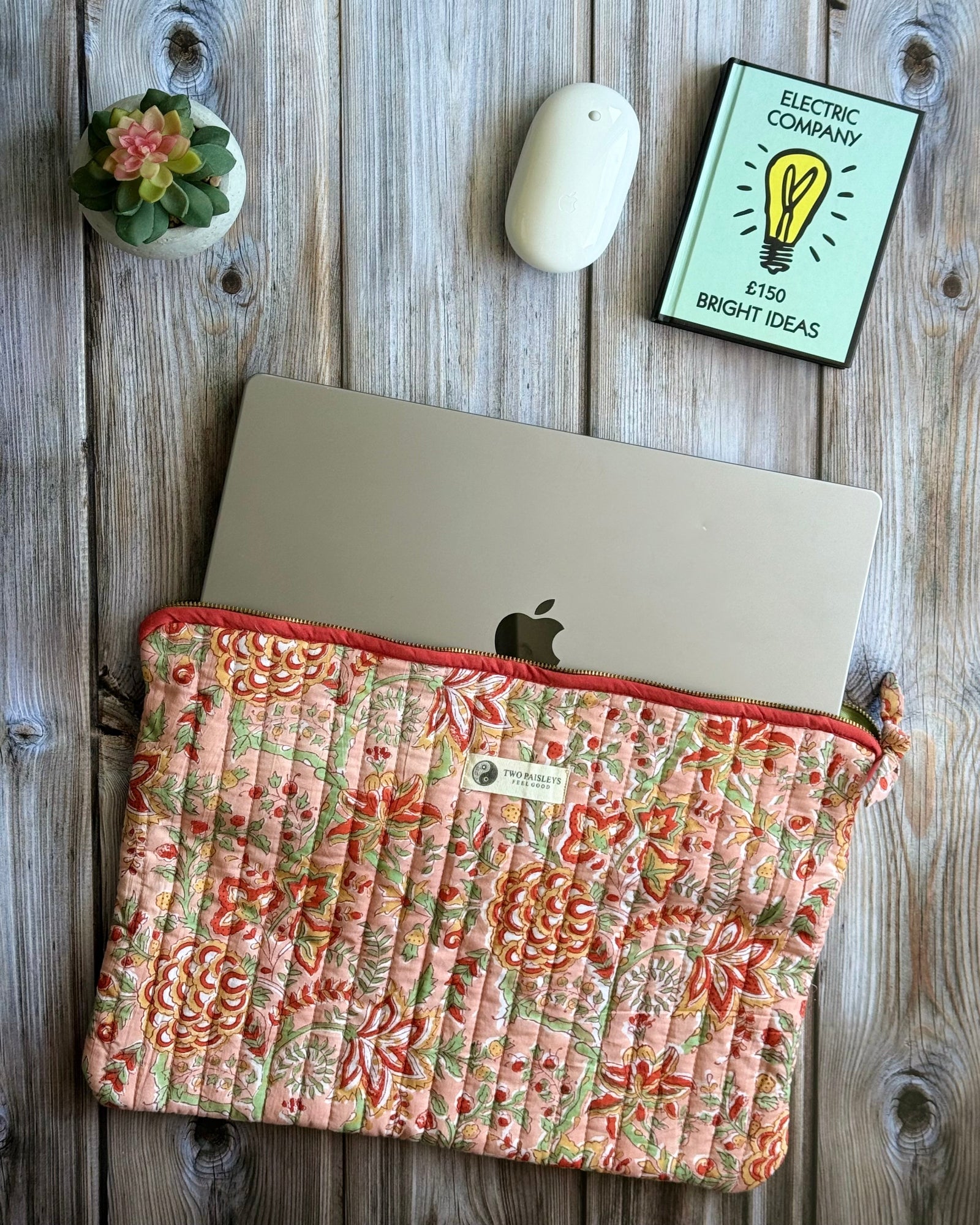 Handblock printed floral quilted laptop sleeve in peach and coral tones, fits 16-inch MacBook.