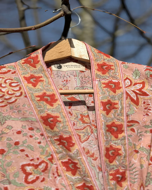 Floral patterned garment on a hanger against a blurred natural background