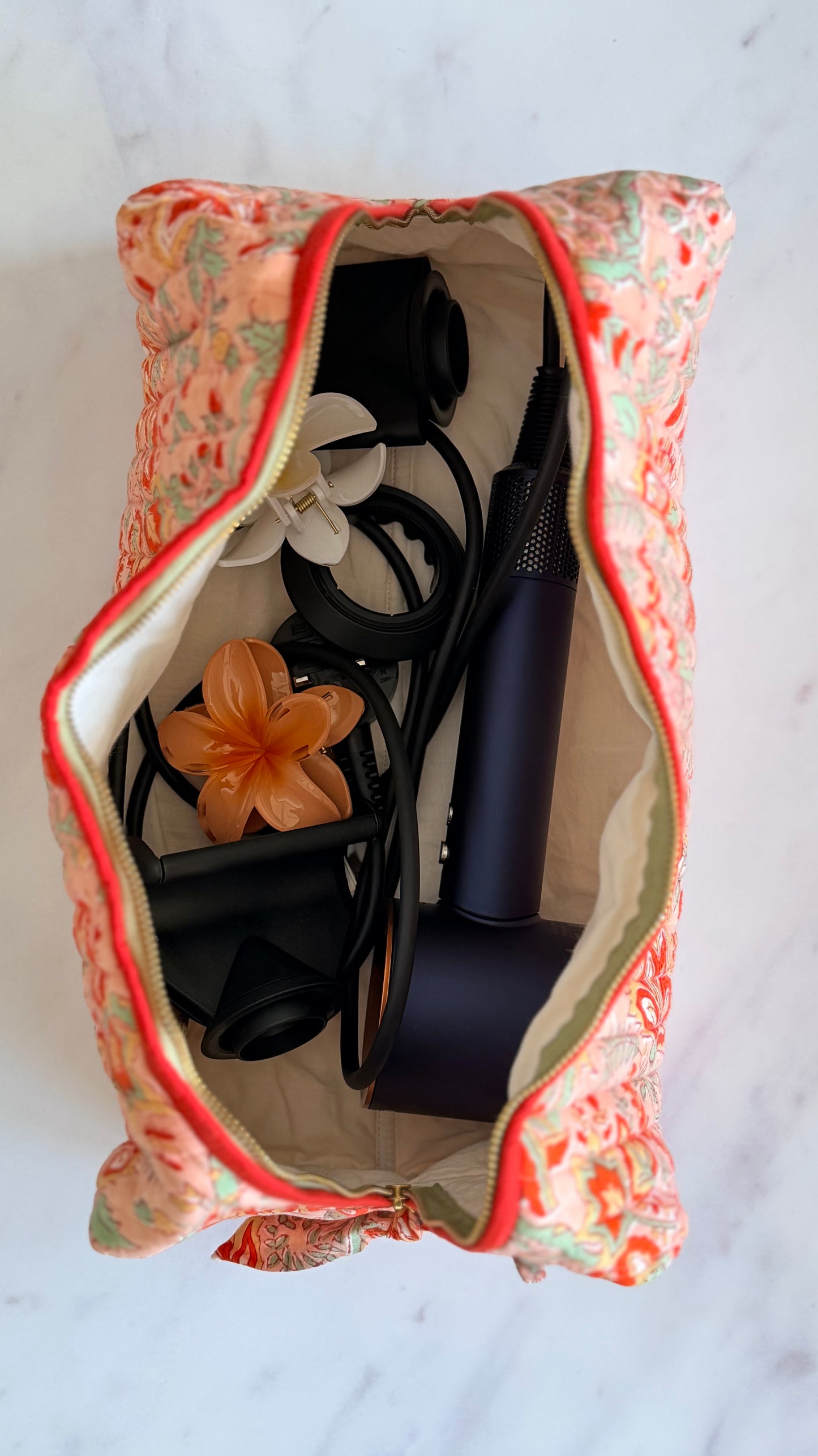 Coral Floral quilted hair tools bag filled with hair dryer attachments and accessories, generously sized padded travel case