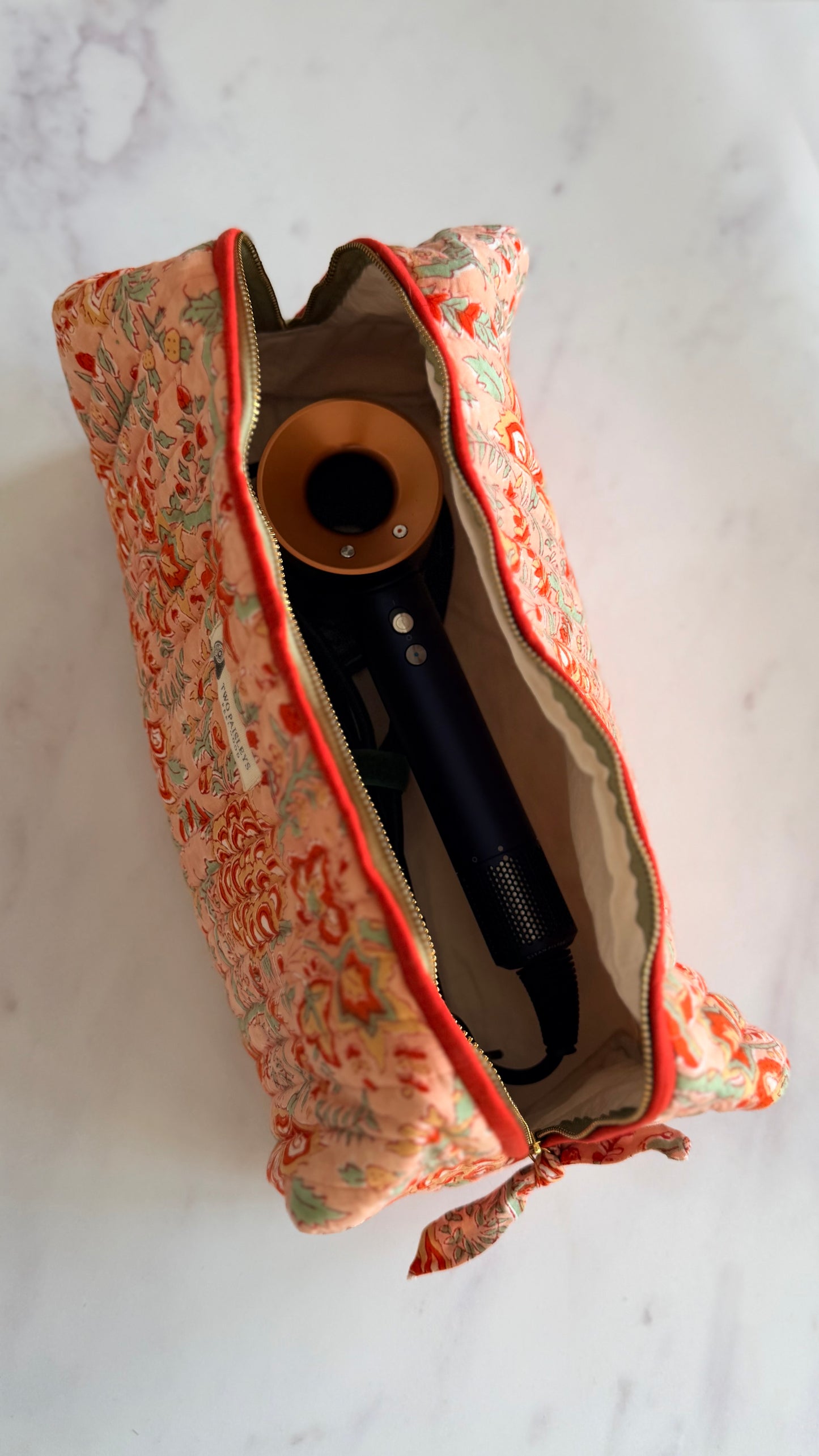 Open Coral Floral quilted hair tools bag with hair dryer inside, wide zip opening and thick natural cotton lining.