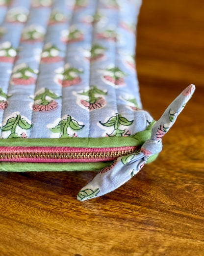 Zoomed in floral pattern and pink zipper on a wooden surface