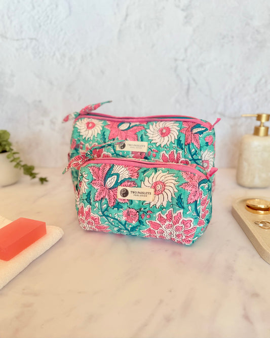 Floral-patterned cosmetic bag on a marble surface with a white background