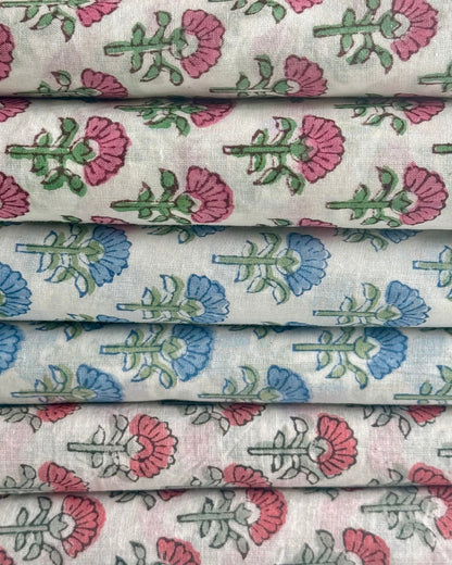 Stack of fabric with floral patterns in pink, blue, and green on a white background