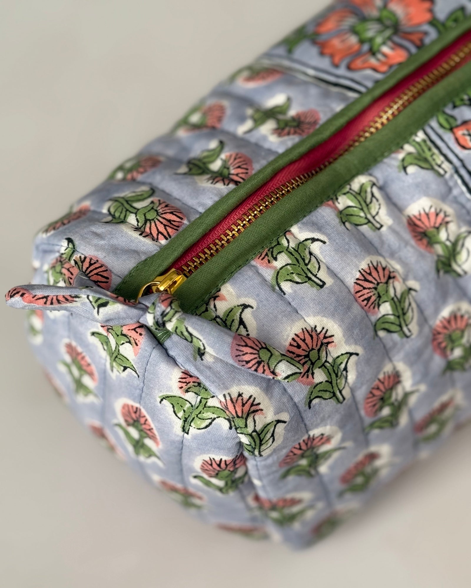 Detail view of gold zip with green piping a