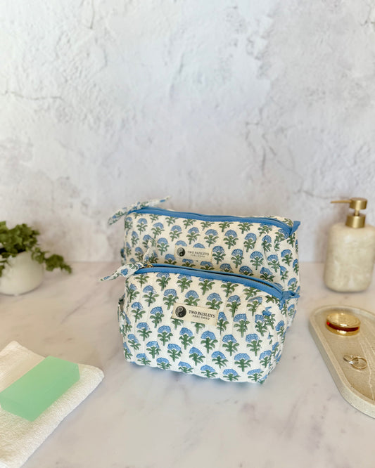 Floral-patterned toiletry bag on a marble surface with a white wall background