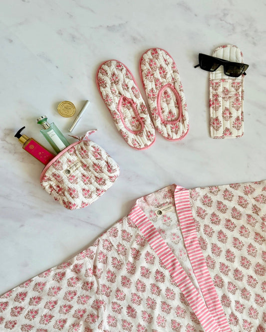 Set of floral-patterned pouches and accessories on a marble surface