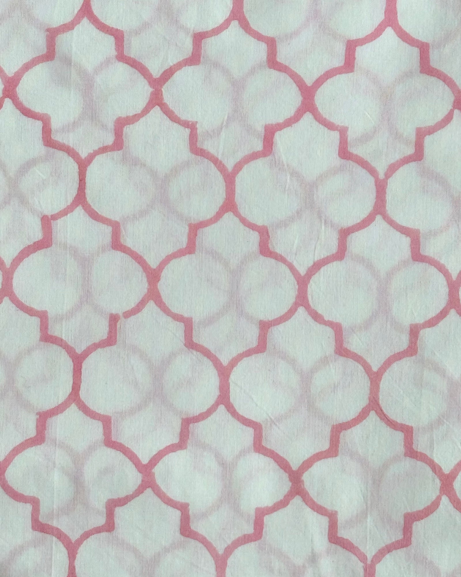A close-up of the Rose Trellis Hand Block Print Cotton Fabric, showcasing the classic geometric quatrefoil pattern in a fresh rose pink