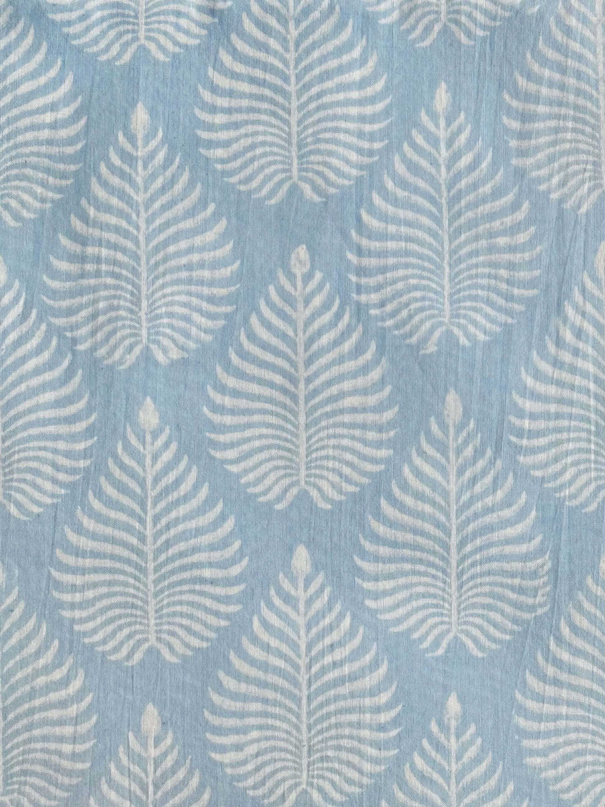 A close-up of our Fern Garden discharge block print fabric in a soft sky blue  colour