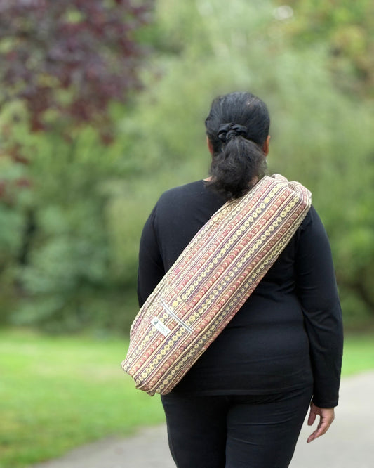 Person wearing a patterned bag over one shoulder outdoors