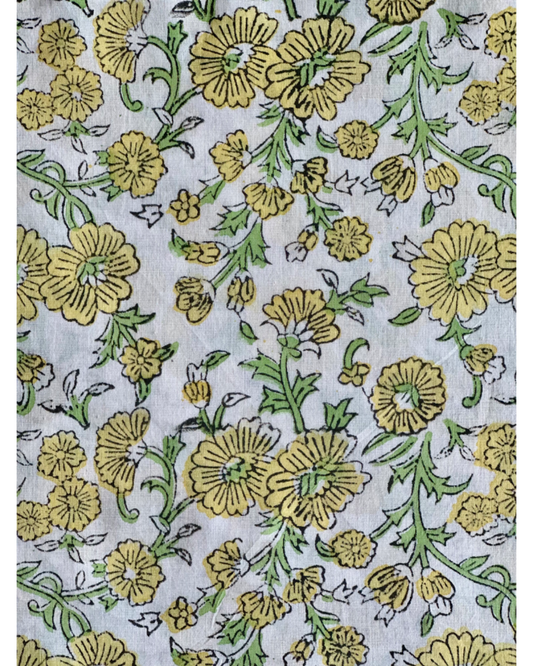 A detailed close-up of the Spring Daisy Hand Block Print Cotton Fabric, showcasing the cheerful yellow daisy floral jaal pattern with green leaves.