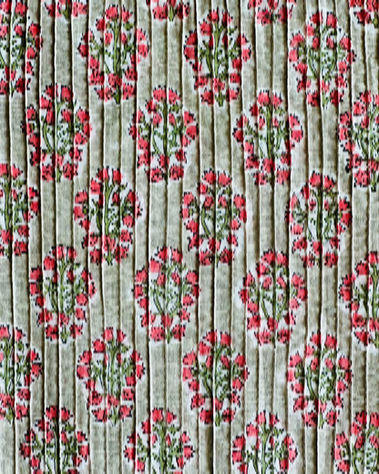A detailed close-up of the Verdant Rose Hand Block Print Pintuck Fabric, showing the fine vertical pintucks and the coral floral pattern on a sage green background.