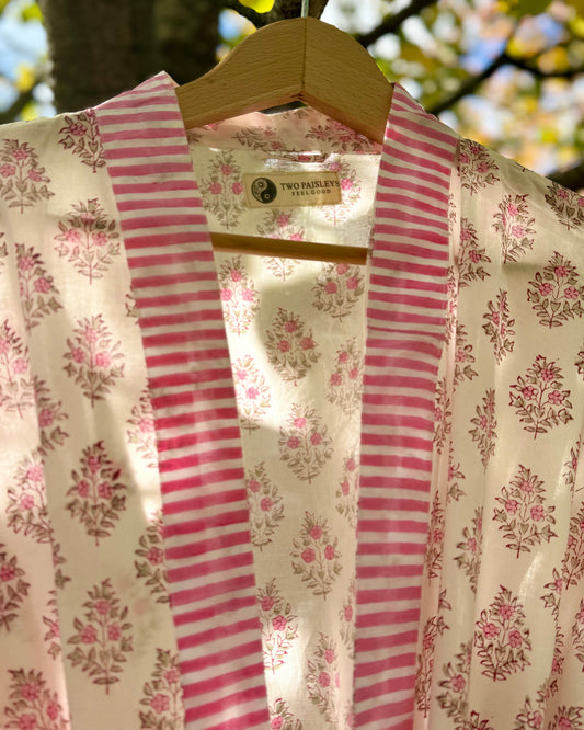 Close-up detail of the pink floral block print cotton robe, showing the striped collar and "The Two Paisleys Feel Good" brand label