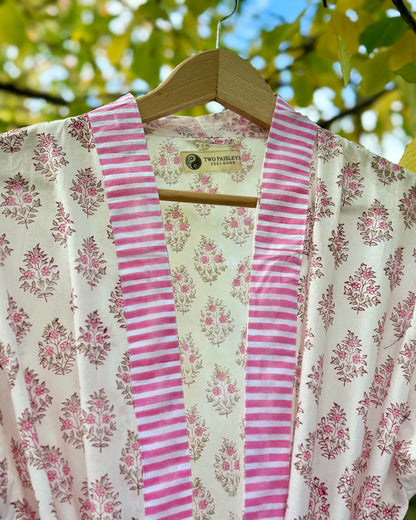 Close-up detail of the pink floral block print cotton robe, showing the striped collar and "The Two Paisleys Feel Good" brand label
