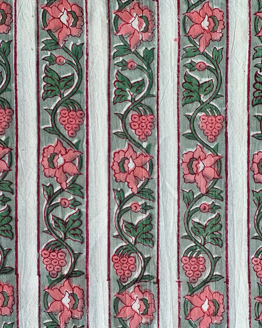 A close-up of the Vintage Vine Hand Block Print Cotton Fabric, showcasing the traditional vertical stripe with a coral pink floral and berry vine on a sage green background.