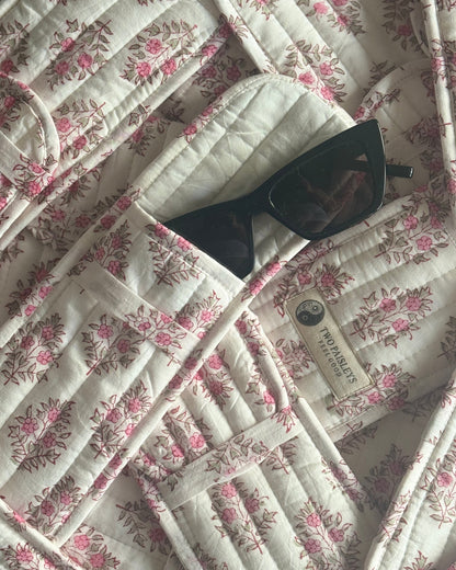 Floral-patterned quilt with sunglasses on top