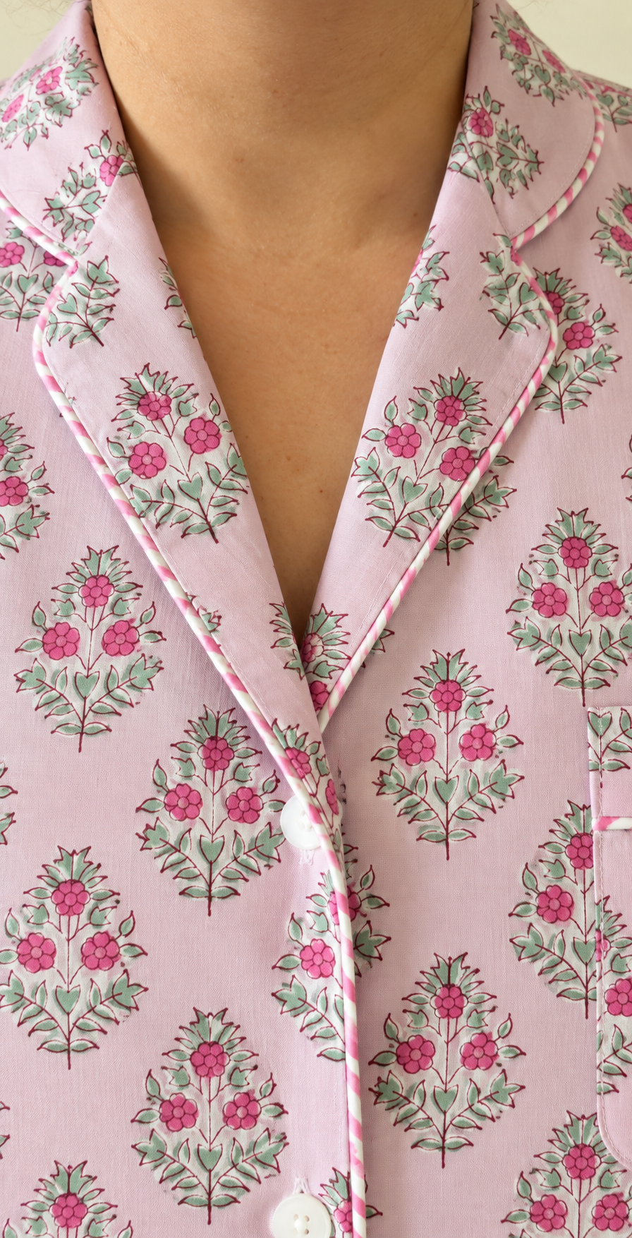 Close-up of the notch collar and striped piping detail on Two Paisleys pink floral block printed cotton pyjama top