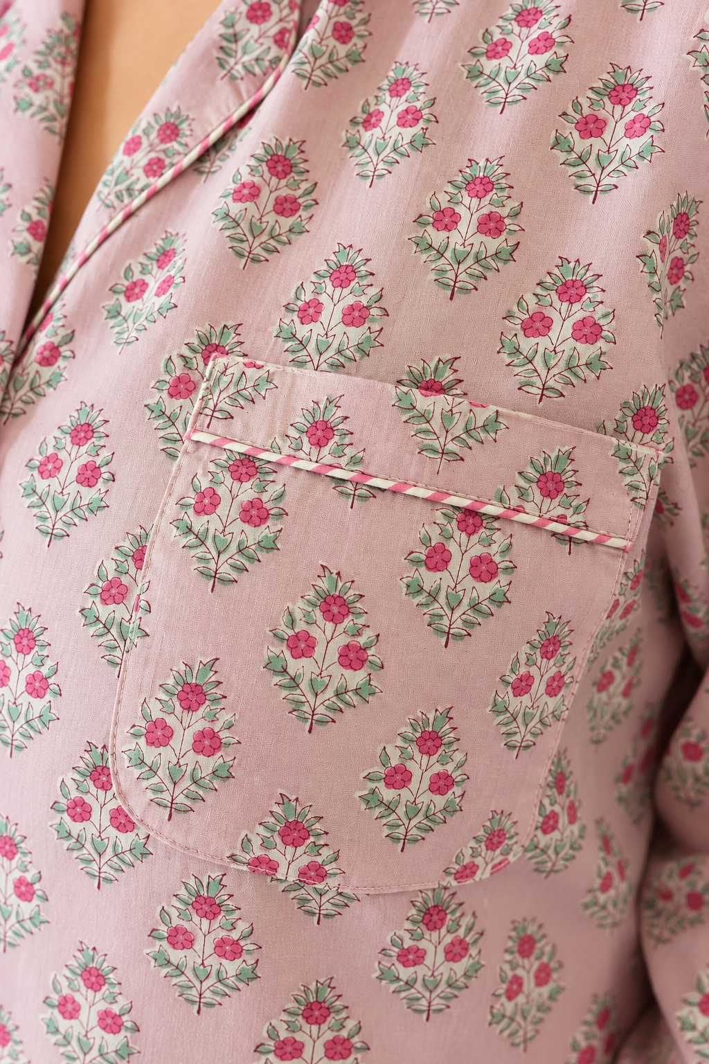 Detailed view of the chest patch pocket and striped trim on Two Paisleys pink hand block printed pyjama shirt