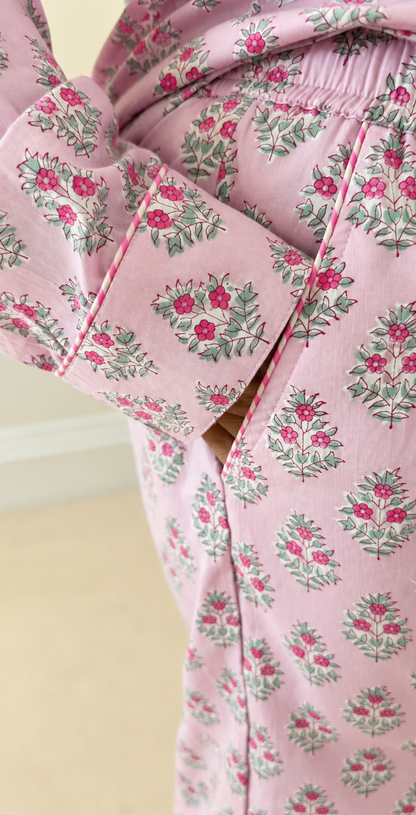 Close-up showing the sleeve cuff and trouser side pocket with striped piping on Two Paisleys pink cotton pyjamas