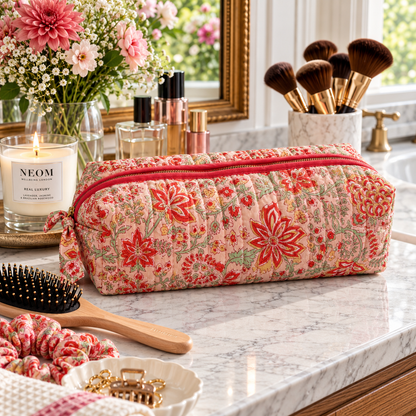  Two Paisleys Coral Floral quilted cotton hair tools bag displayed on a marble bathroom vanity next to a candle and hairbrush
