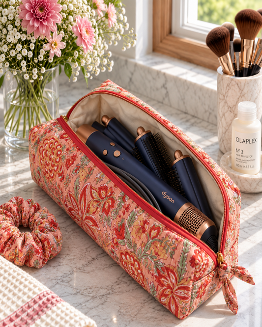 Open Two Paisleys Coral Floral quilted cotton travel bag holding a Dyson Airwrap multi-styler and attachments on a vanity unit