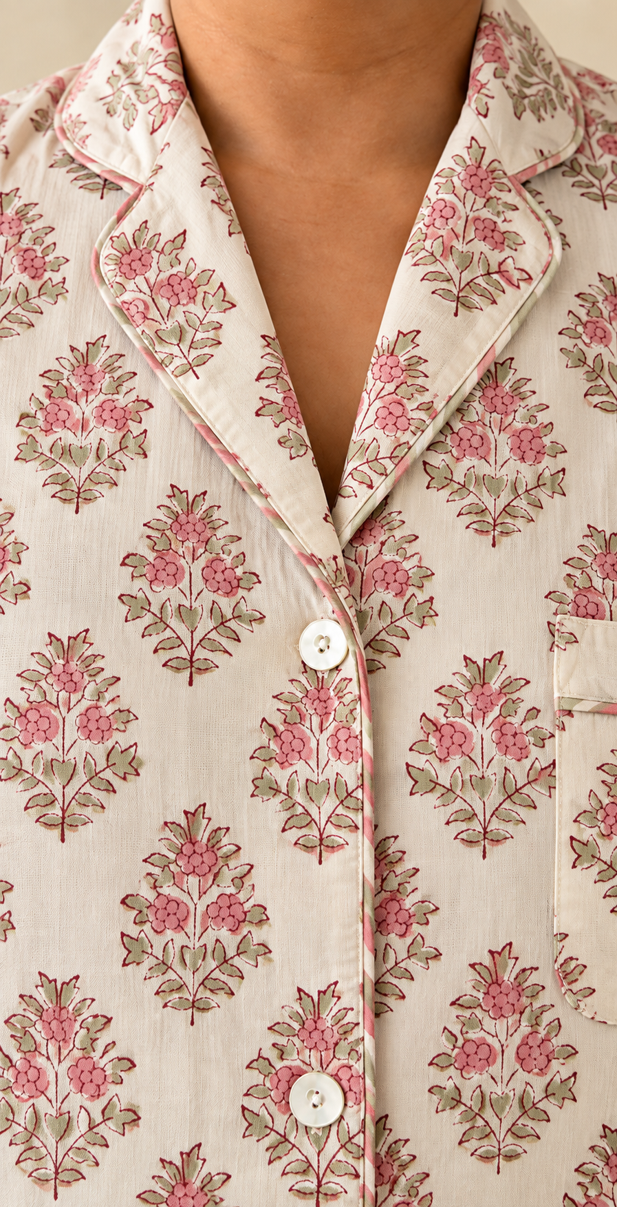 Close-up of notch collar and buttons on Two Paisleys hand block printed cotton pyjama shirt in vintage pink floral pattern